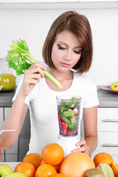 Jovem mulher bonita usando liquidificador, preparando suco de laranja — Fotografia de Stock