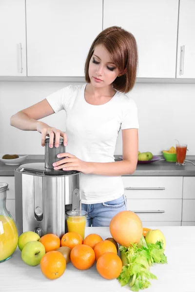 Ung vacker kvinna med juicer, förbereda färsk juice — Stockfoto