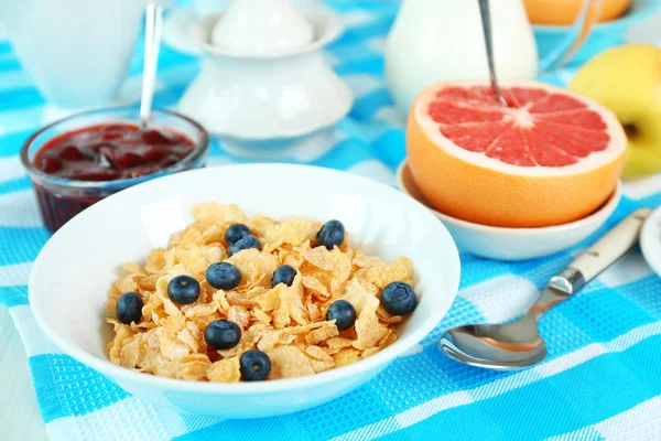 Välsmakande cornflakes med frukter och bär på bordet på nära håll — Stockfoto