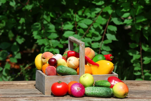 Haufen frisches Obst und Gemüse in Kisten auf dem Tisch im Freien — Stockfoto