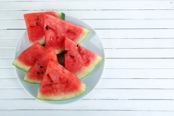 Snijvlakken van rijpe watermeloen op houten ondergrond — Stockfoto