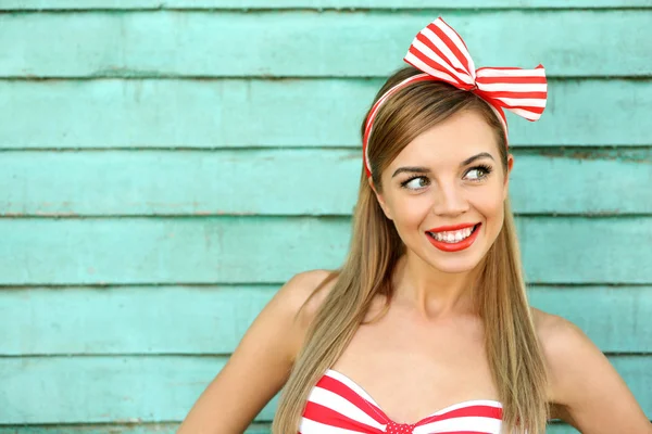 Schönes Mädchen mit hübschem Lächeln auf farbigem Holzhintergrund — Stockfoto