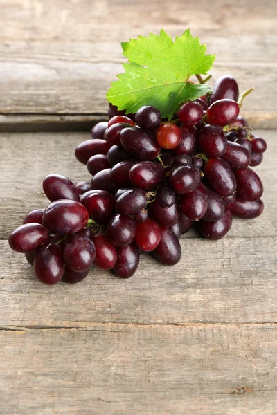 Fresh ripe grapes on old wooden table — Stock Photo, Image