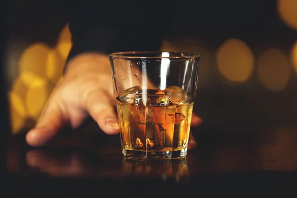 Kubek szkło whisky w męskiej ręki na kontuar barowy — Zdjęcie stockowe