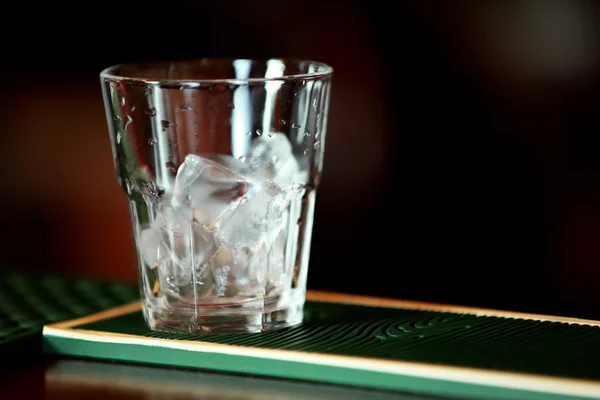 Glass with ice on bar counter — Stock Photo, Image