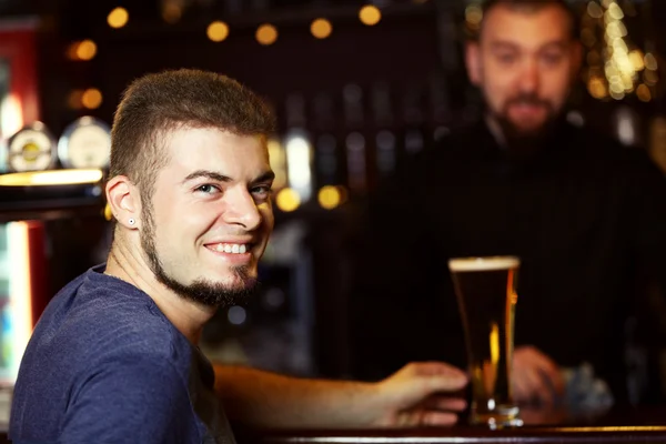 Man drinking beer in bar — Stock Photo, Image