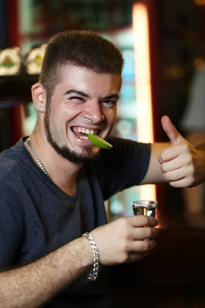 man drinking tequila in bar