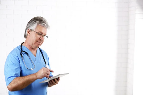 Médico com tablet digital em fundo claro — Fotografia de Stock