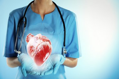 Steteskoplu doktor kalbi tutuyor.