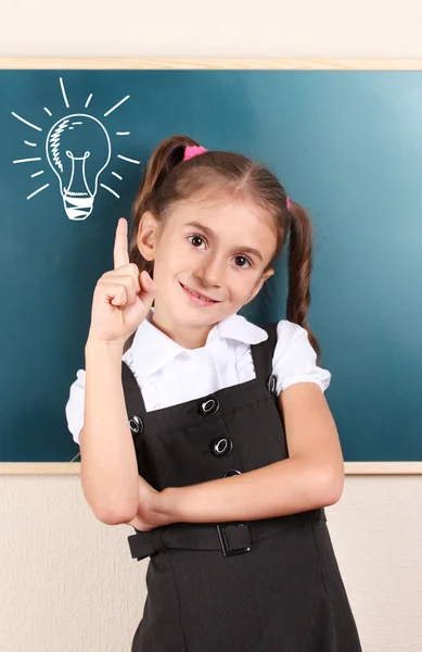 Niña con idea bombilla por encima de la cabeza — Foto de Stock