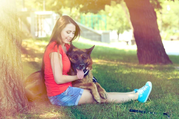 Chica joven con perro en el parque — Foto de Stock