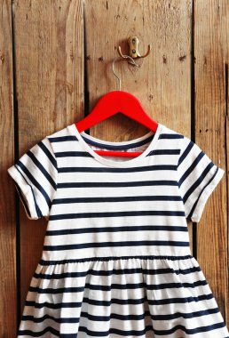 Çocuk elbise askı üzerinde ahşap duvar üzerinde