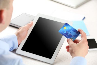 Kredi kartı ve tablet tutan adam