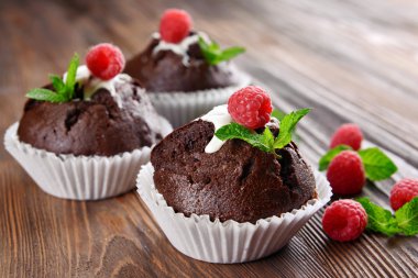 Çilek ve ahşap masa üzerinde taze nane ile lezzetli çikolata cupcakes yakın çekim