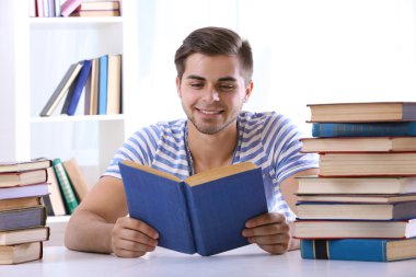 Genç adam masada kitap okumak