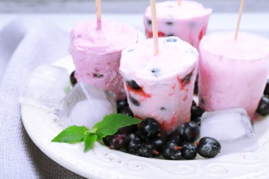 Gri peçete, closeup üzerinde beyaz tabak içinde siyah kuş üzümü ile tatlı dondurma