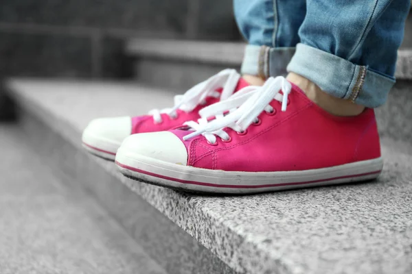 Pies femeninos en zapatos de goma rosa — Foto de Stock