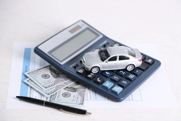 おもちゃの車、お金、書類、テーブル上の電卓。車保険のコンセプト — ストック写真