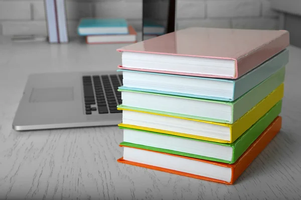 Stapel boeken met laptop — Stockfoto