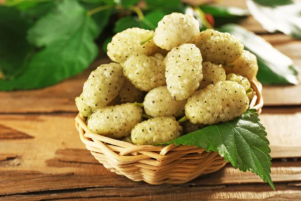 Fresh mulberry in wicker basket on wooden table, closeup — Stock Photo, Image