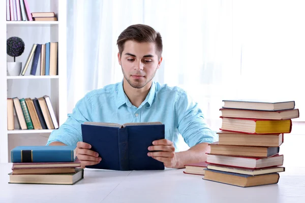 Młody człowiek czytania książki w tabeli — Zdjęcie stockowe