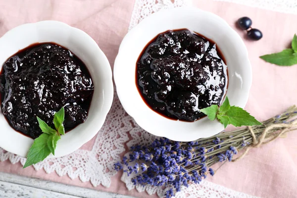 Tasty currant jam with berries on table close up — Stock Photo, Image