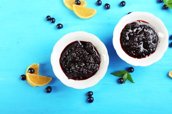 Tasty currant jam with berries on table close up — Stock Photo, Image