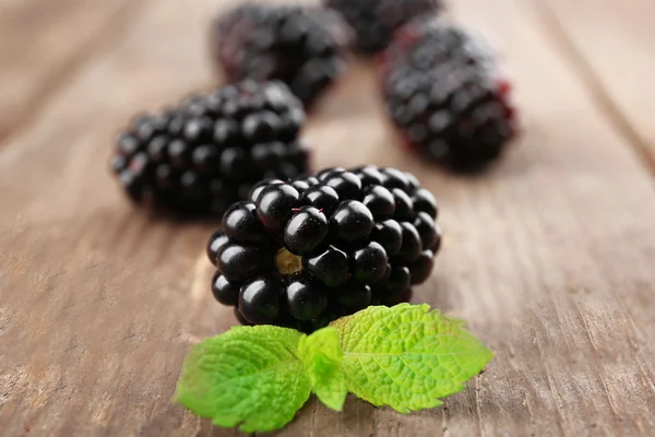 Moras maduras con hojas verdes sobre fondo de madera —  Fotos de Stock