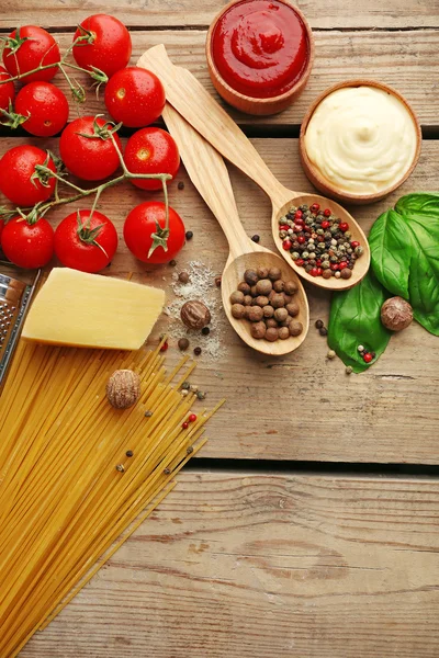 Pasta spaghetti met tomaten, kaas en basilicum op rustieke houten achtergrond — Stockfoto