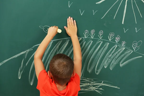 Jongen tekening op blackboard — Stockfoto