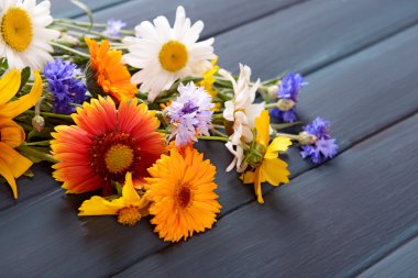 Ahşap masa üzerinde parlak kır çiçekleri