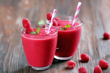 Ahşap masa üzerinde çilek ile Ahududu milkshake bardak yakın çekim