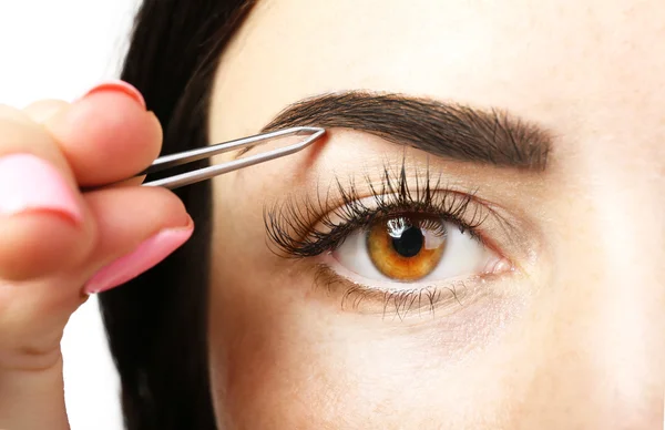 Young woman plucking eyebrows — Stock Photo, Image
