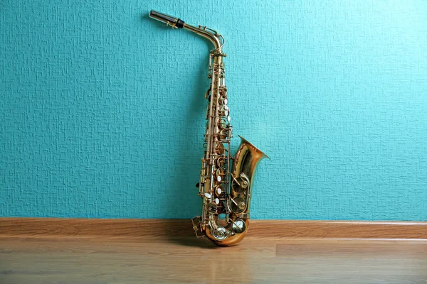 Saxophone on turquoise wallpaper background — Stock Photo, Image
