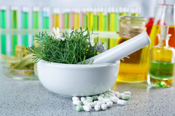 Herbs in mortar and pills — Stock Photo, Image