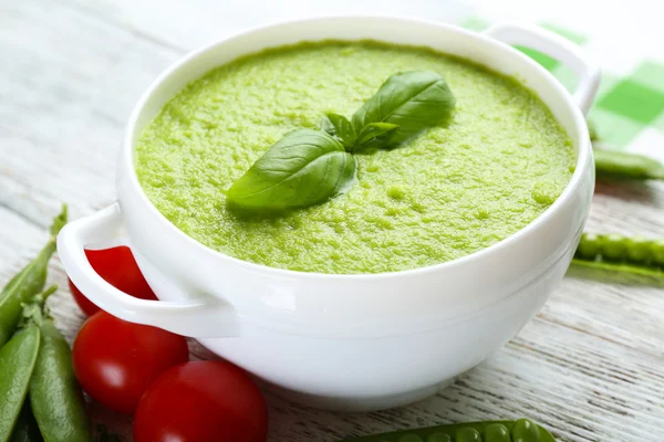 Tasty peas soup and cherry tomatoes on table close up — Stock Photo, Image