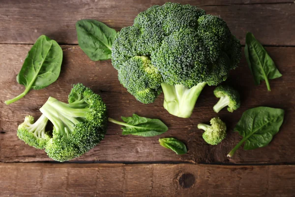 Brócoli fresco con espinacas en la mesa de madera de cerca — Foto de Stock