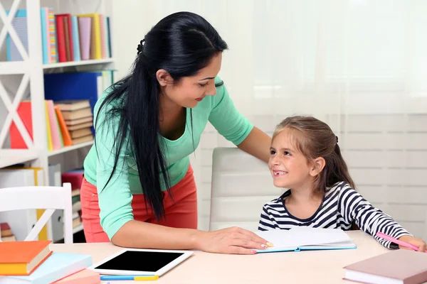 Schulmädchen macht Hausaufgaben mit Mutter — Stockfoto