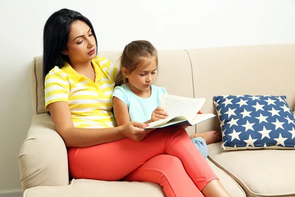 어린 소녀가 어머니와 함께 책을 읽고 — 스톡 사진