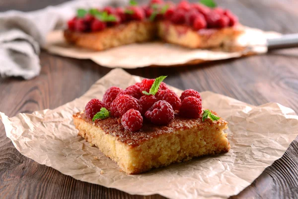 Tarte fraîche à la framboise sur parchemin sur table en bois, gros plan — Photo