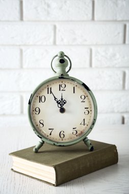 Işık duvar arka plan üzerinde saat ve vintage kitap