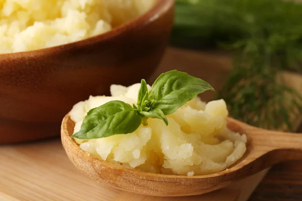 Purê de batatas em colher na tábua de corte de madeira, close-up — Fotografia de Stock