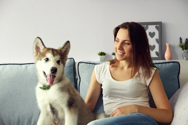 Jeune femme couchée avec chien malamute — Photo