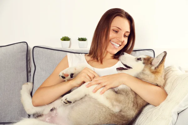 Young woman lying with malamute dog — Stock Photo, Image