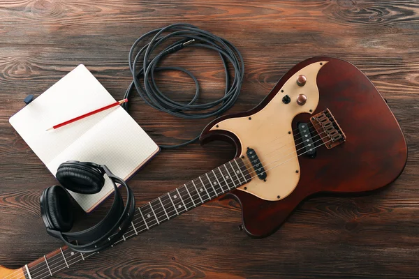 Electric guitar with headphones and notebook — Stock Photo, Image