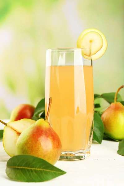 Glas med färska päron på träbord på suddig bakgrund — Stockfoto