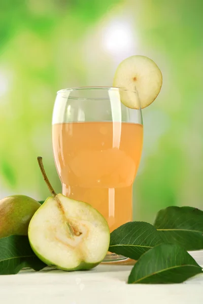 Glas med färska päron på träbord på suddig bakgrund — Stockfoto