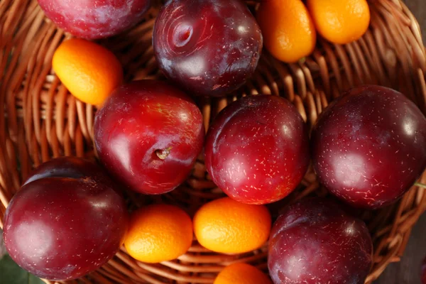Ripe plums on wicker tray — Stock Photo, Image