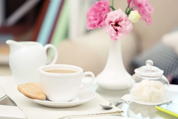 Cup of coffee on table in living room — Stock Photo, Image