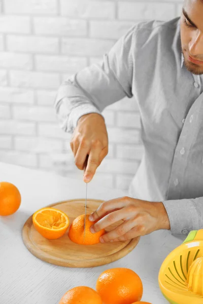 Hombre joven preparando jugo de naranja —  Fotos de Stock